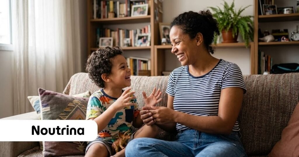 Mulher negra sorrindo e conversando com seu filho pequeno no sofá da sala de casa, enquanto o menino sorri e segura um brinquedo articulado, exemplificando de forma prática como falar sobre Jesus para uma criança em um ambiente acolhedor.